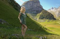 Обнаженная блондинка снимает платье в горах